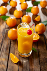 Orange juice and fresh fruits on an old wooden table.