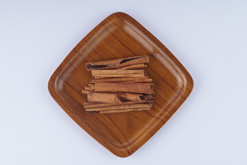 several pieces of cinnamon bark spice on a white table with studio lighting