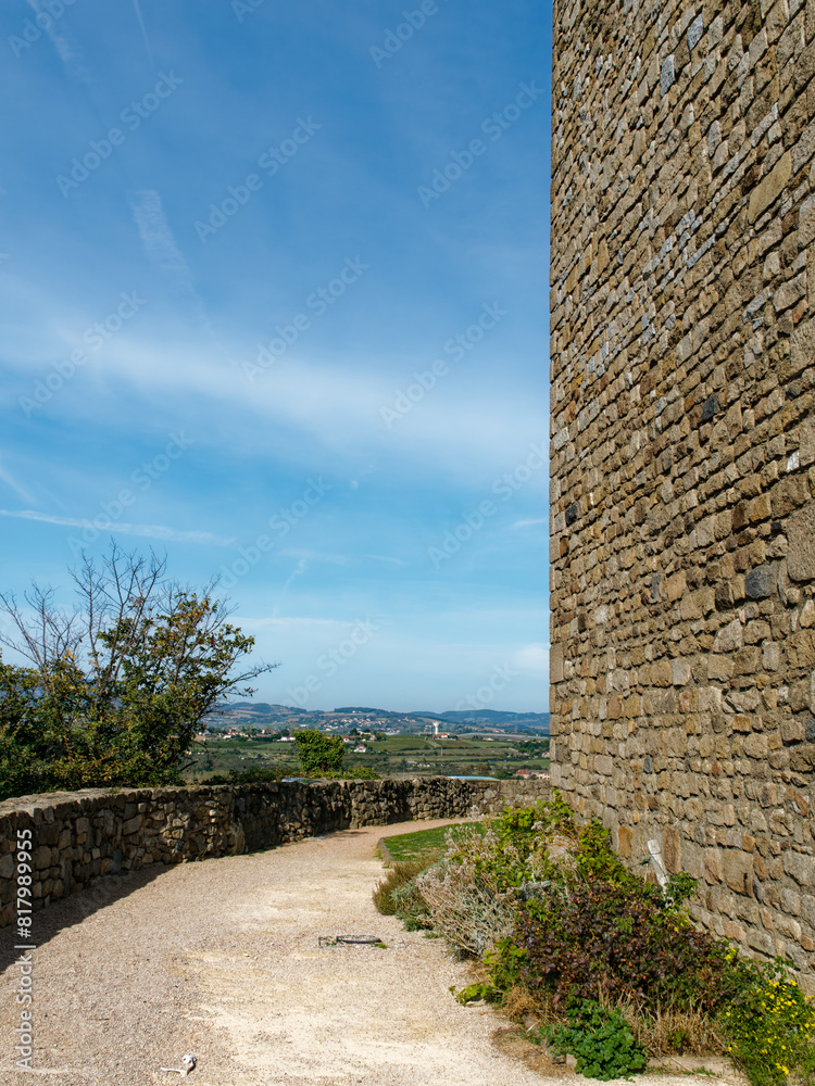 Wall mural wall of the water tower in montagny (france) with path and landscape, blue sky with clouds