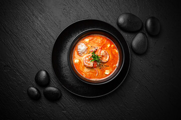 Composition of tom yam soup with shrimp and rice on black background. The Art of Japanese Cuisine....