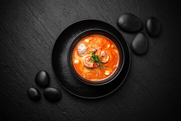 Composition of tom yam soup with shrimp and rice on black background. The Art of Japanese Cuisine. Food photography for menu and sushi bar decoration