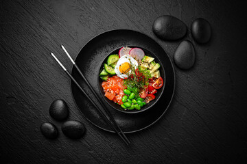 Salmon Poke bowl composition on black background. The Art of Japanese Cuisine. Food photography for...