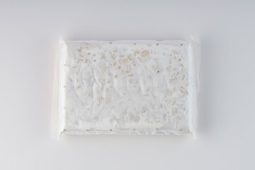 raw tempeh in plastic wrap on a white background with studio lighting