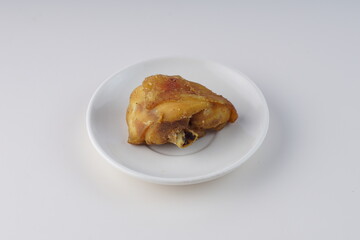 pieces of fried chicken on a white plate on a white table with studio lighting