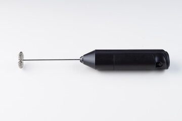 Electric hand coffee stirrer over white background with studio lighting