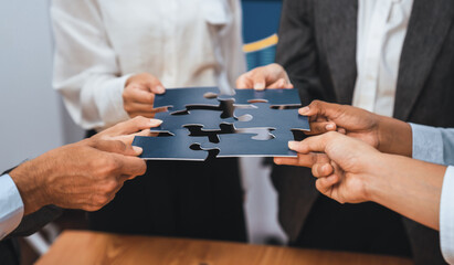 Corporate officer worker collaborate in office, connecting puzzle pieces with report paper on table...