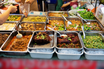 A table full of food with a The thai food is in many different dishes and is served in a buffet...