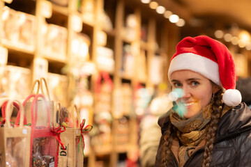 junge attraktive Frau beim shoppen auf dem Weihnachtsmarkt, Lichterglanz und weihnachtliche Stimmung in der Stadt.