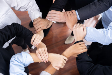 Multicultural business people holding hand together in circle. Unity teamwork in office business...