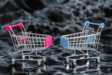 Two miniature shopping carts against a dark black marble background.