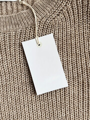White paper tag on a brown woolen sweater
