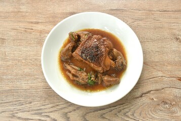 steamed chicken thigh and feet with garlic black pepper gravy sauce stew on plate
