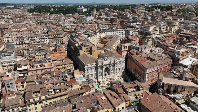 La fontana di Trevi a Roma, gremita di turisti, vista dall'alto.
Ripresa aerea con drone di Fontana di Trevi piena di visitatori in una giornata estiva.