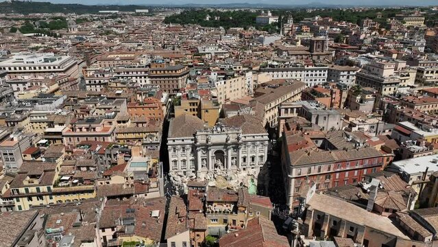 La fontana di Trevi a Roma, gremita di turisti, vista dall'alto.
Ripresa aerea con drone di Fontana di Trevi piena di visitatori in una giornata estiva.