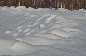 Russia. Kuznetsk Alatau. Snowdrifts run along the winter taiga road.