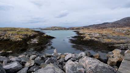 Rugged and rocky coastal landscape overlooking ocean from the causeway between Eriskay and South...