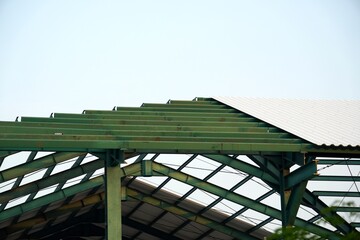 
The roof of a large warehouse under construction, featuring a green iron frame with partially installed roofing.
