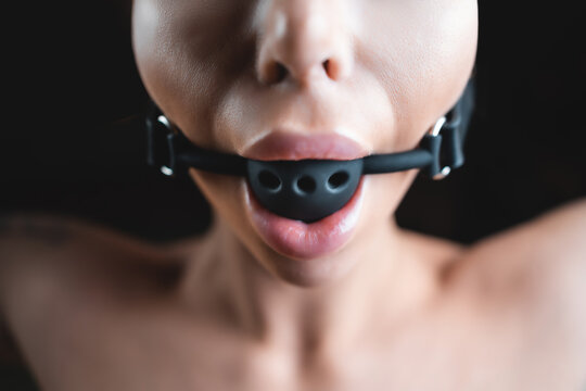 naked young sexy woman with gag ball in mouth, bdsm domination role playing games and fetish