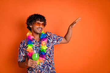 Photo of attractive young man dancing hold cocktail enjoy summer dressed stylish colorful clothes isolated on orange color background