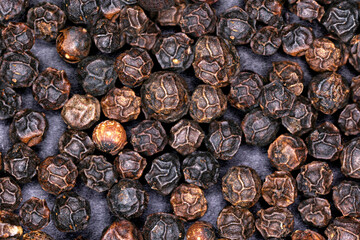 Black peppercorns close up background