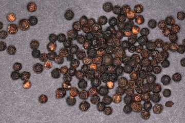 Black peppercorns in closeup background