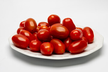 Dojrzałe czerwone pomidory na białym tle.