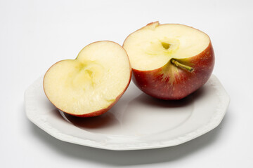 Rozcięte na dwie połówki jabłko na białym talerzu. © MR. Stanek