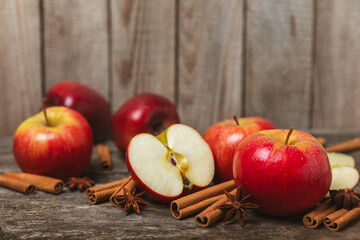 Apples with cinnamon on a textured wooden background. Fragrant red spiced apples with cinnamon...
