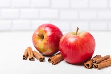 Apples with cinnamon on a textured wooden background. Fragrant red spiced apples with cinnamon sticks and star anise. Apple slices with spicy spices. Place for text. Copy space. Harvesting. Fruits. 