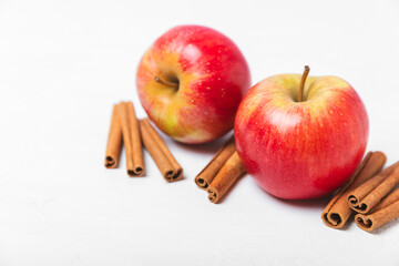 Apples with cinnamon on a textured wooden background. Fragrant red spiced apples with cinnamon sticks and star anise. Apple slices with spicy spices. Place for text. Copy space. Harvesting. Fruits. 