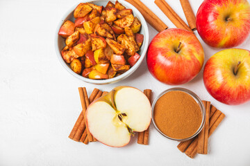 Apples with cinnamon on a textured wooden background. Fragrant red spiced apples with cinnamon sticks and star anise. Apple slices with spicy spices. Place for text. Copy space. Harvesting. Fruits. 
