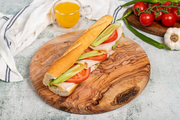 light sandwich on wood serving board. Sandwich with smoked turkey, labneh cheese, tomato, cucumber and lettuce