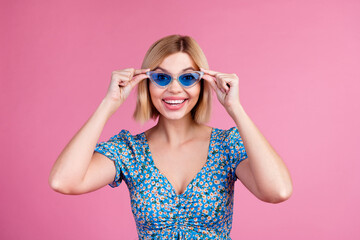 Photo of shiny attractive lady dressed blue top dark glasses smiling empty space isolated pink color background