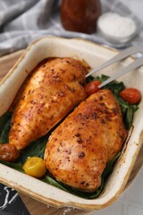 Baked chicken fillets with vegetables and marinade on white table, closeup