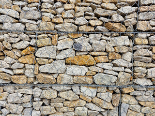 stones in the iron fence used to strengthen the edge of the structure. natural material, decorative wall. landscape design