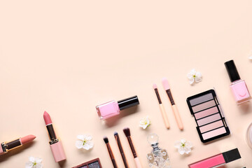 Flat lay composition with different makeup products and beautiful spring flowers on beige...