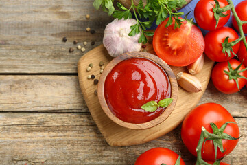 Tasty ketchup, fresh tomatoes, parsley and spices on wooden table, flat lay. Space for text