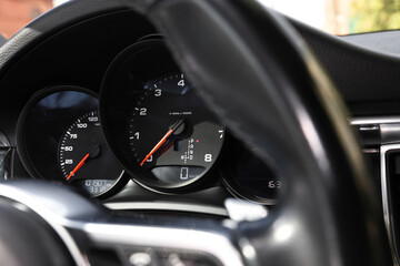 Steering wheel, speedometer and tachometer inside of modern car, closeup