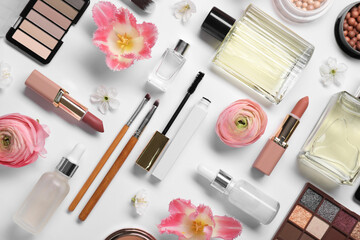 Flat lay composition with different makeup products and beautiful spring flowers on white background