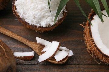 Coconut flakes, spoon and nut on wooden table