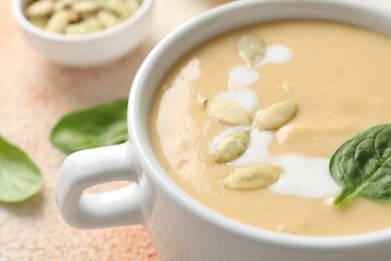 Healthy cream soup high in vegetable fats on color textured table, closeup