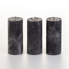 Set of four black palm wax candles with unique ice-like patterns arranged on white background....