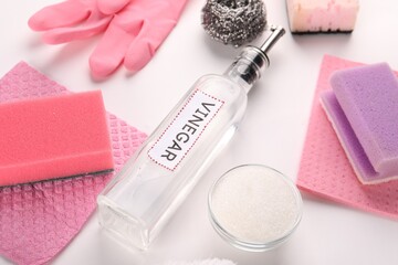 Naklejka premium Eco friendly natural cleaners. Vinegar in bottle, bowl of soda, sponges and gloves on white background