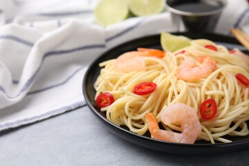 Tasty spaghetti with shrimps and chili pepper on grey table, closeup. Space for text
