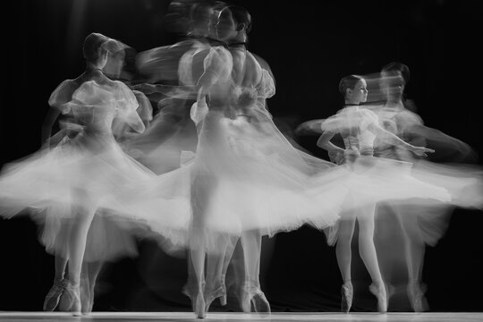 Naklejki Ghostly silhouettes of ballerinas performing pirouettes on stage. Black and white photo with long exposure. Timeless. Concept of beauty, classic and modernity, contemporary art. Ad