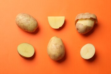 Fresh raw potatoes on orange background, flat lay