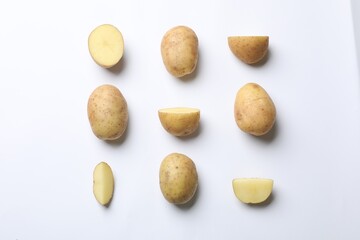 Fototapeta na wymiar Fresh raw potatoes on white background, flat lay