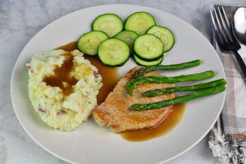 pork chop top wiith asparagus served with mash potatoes