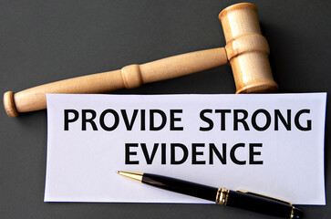 PROVIDE STRONG EVIDENCE - words on white paper on dark background with judge's gavel