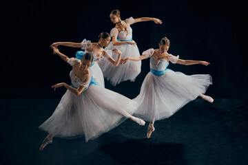 Image of young female ballet dancers in synchronized motion, their white tutus creating fluid...